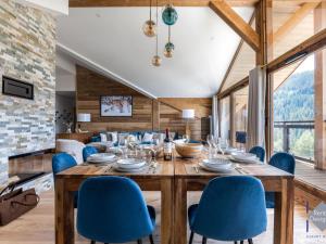 a dining room with a large wooden table and blue chairs at Appartement Courchevel, 5 pièces, 8 personnes - FR-1-664-21 in Courchevel