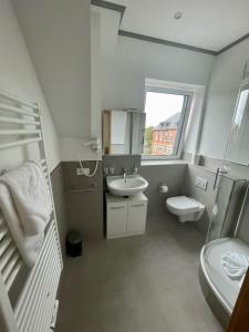 a white bathroom with a sink and a toilet at Lothringer Hof in Saarlouis