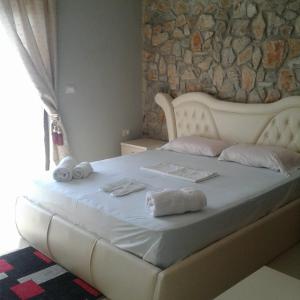 een wit bed met handdoeken in een kamer bij Hotel Villa Stone Dream Bar Restaurant in Pogradec