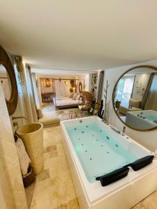 a large bathroom with a tub and a mirror at Buddha Beach Thoiry in Thoiry