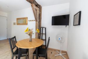 a dining room with a table and chairs and a tv at La Suite Littéraire, 5mn du ZooParc de Beauval in Saint-Aignan