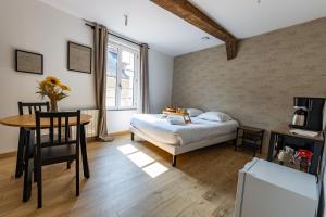 a bedroom with a bed and a table and a desk at La Suite Littéraire, 5mn du ZooParc de Beauval in Saint-Aignan