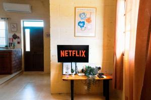 a desk with a netflix sign on a wall at Kampanjola in San Lawrenz