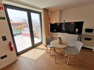 a kitchen with a table and chairs in a room at Chalé Esmeralda - Charming Studios in Calheta Beach in Calheta