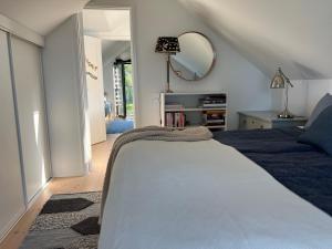 a bedroom with a bed and a mirror on the wall at Stylish lake view house in Vadstena