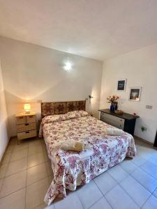 a bedroom with a bed and a night stand and a table at San Teodoro Appartamento Vacanze Centro in San Teodoro