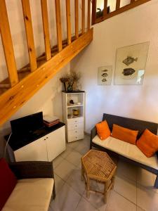 a living room with a couch and a staircase at San Teodoro Appartamento Vacanze Centro in San Teodoro