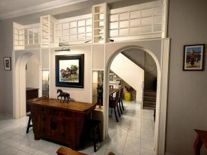 sala de estar con arco y mesa de madera en LS Colonial Styled 4BR Bangalow, en Tanjung Bungah