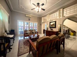 - un salon avec un canapé et un ventilateur de plafond dans l'établissement LS Colonial Styled 4BR Bangalow, à Tanjung Bungah