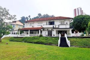 Una gran casa blanca con escaleras en un patio en LS Colonial Styled 4BR Bangalow, en Tanjung Bungah