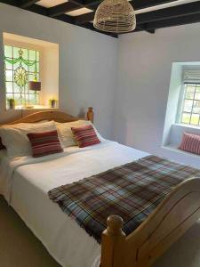 a bedroom with a large bed with red pillows at Windsor Cottage in Milton Abbas