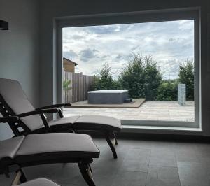 サガルトにあるMare Balticum Urlaub auf Rügenの椅子2脚と大きな窓が備わる客室です。