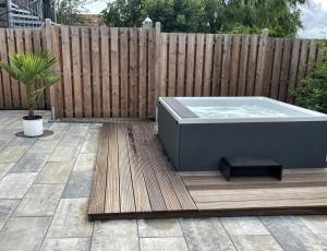 a hot tub sitting on a deck next to a fence at Mare Balticum Urlaub auf Rügen in Sagard