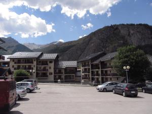 a parking lot with cars parked in front of a mountain at Appartement Valloire, 2 pièces, 4 personnes - FR-1-263-32 in Valloire