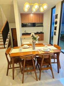 a kitchen and dining room with a wooden table and chairs at Rania Guest House in Salakan