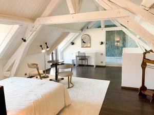 a bedroom with a bed and a desk in a attic at L'hermine de Sologne in Courmemin
