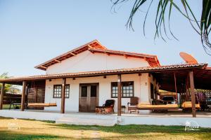 a small white house with a porch at Espaço Varanda e Mar in São Miguel do Gostoso