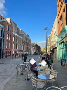 a group of people sitting at tables on a city street at Stunning 2 Bed/2 Bath Flat in Waterloo, London in London