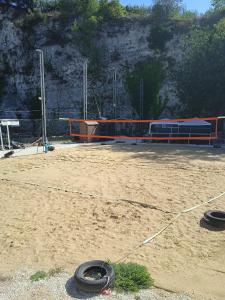 due pneumatici su un terreno sporco con un campo da pallavolo di AREA MULTISPORT Camping & Camper a Canicattini Bagni