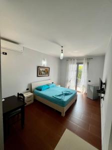 Schlafzimmer mit einem Bett, einem Tisch und einem Fenster in der Unterkunft H&A Guest House in Divjaka
