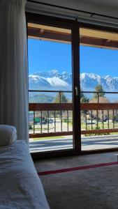 a bedroom with a large window with a view of the mountains at Hotel Cordillera in El Bolsón