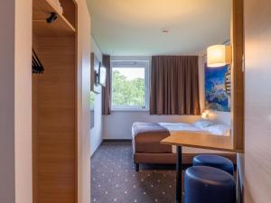 um quarto de hotel com uma cama e uma mesa em B&B Hotel Stuttgart-Airport/Messe em Estugarda