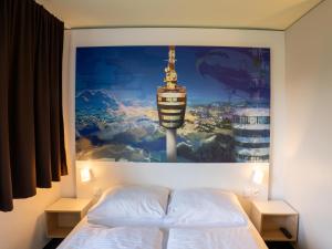 a bedroom with a large painting above a bed at B&B Hotel Stuttgart-Airport/Messe in Stuttgart