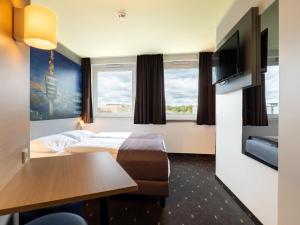 B&B Hotel Stuttgart-Airport/Messe في شتوتغارت: غرفة الفندق بسرير وطاولة