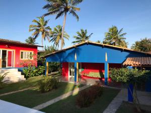 una casa azul y roja con palmeras en el fondo en Casa Colorida, en Pipa