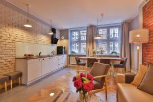 a kitchen and living room with a table and chairs at Apartament Bursztynowy Mariacka Old Town in Gdańsk