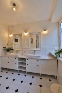 a bathroom with two sinks and two mirrors at Apartament Bursztynowy Mariacka Old Town in Gdańsk