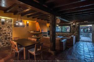 a kitchen and living room with a table and chairs at CASA RURAL LA CORVA in Triollo