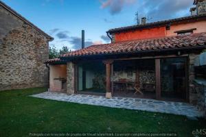 einen Außenblick auf ein Haus mit einer Terrasse in der Unterkunft Casa rural la corva in Triollo