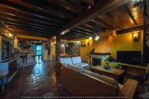 a living room with couches and a table and a kitchen at CASA RURAL LA CORVA in Triollo
