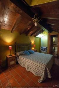 a bedroom with a large bed with a wooden ceiling at Casa rural la parda in Triollo