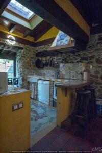 a kitchen with a island in a stone kitchen at Casa rural la parda in Triollo
