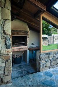 an outdoor pizza oven in a stone building at Casa rural la parda in Triollo