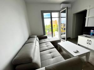 ein Wohnzimmer mit einem Sofa und einem Tisch in der Unterkunft H&A Guest House in Divjaka