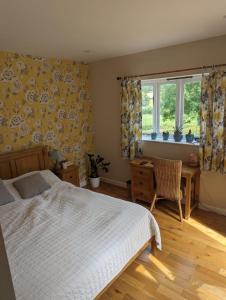 Schlafzimmer mit einem Bett, einem Schreibtisch und Fenstern in der Unterkunft The Willoughby in Little Bytham