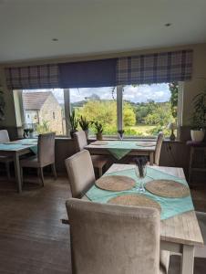 a dining room with tables and chairs and a large window at The Willoughby in Little Bytham