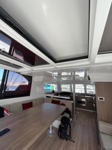 Private Exclusive Catamaran 'Hang Loose' في برشلونة: غرفة طعام مع طاولة وتلفزيون على السقف