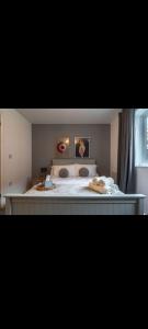 um quarto com uma cama grande e pinturas em Glasshoughton Platinum em Castleford