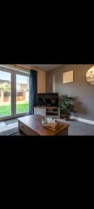 a living room with a table and a large window at Glasshoughton Platinum in Castleford