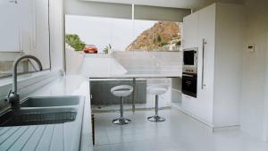 a kitchen with a sink and two stools at Jeema lodge in Hatta