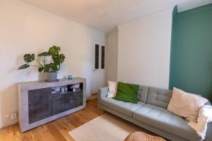 a living room with a couch and a potted plant at Milton Keynes Cosy Guest House in Milton Keynes