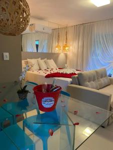 uma sala de estar com uma cama e uma mesa de vidro em Villas do Pratagy Jambo I com Jacuzzy em Maceió