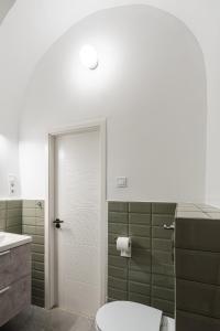 een badkamer met een toilet en een douche met groene tegels bij Hungarikum Studios in Boedapest