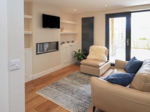 a living room with a couch and a chair at Wee Smithy in Munlochy