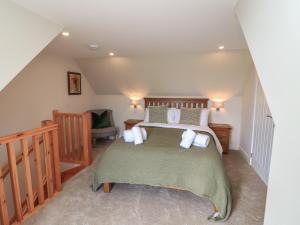 a bedroom with a large bed and a staircase at Wee Smithy in Munlochy