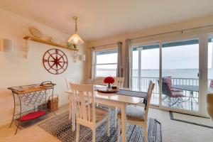 ein Esszimmer mit einem Tisch und Stühlen sowie Meerblick in der Unterkunft Beachfront Onekama Vacation Rental with Balcony! in Onekama